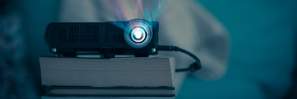 black projector on stack of books