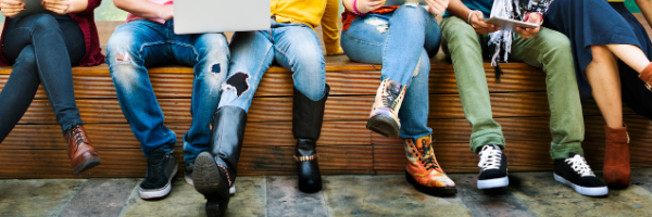 people sitting on bench using electronics