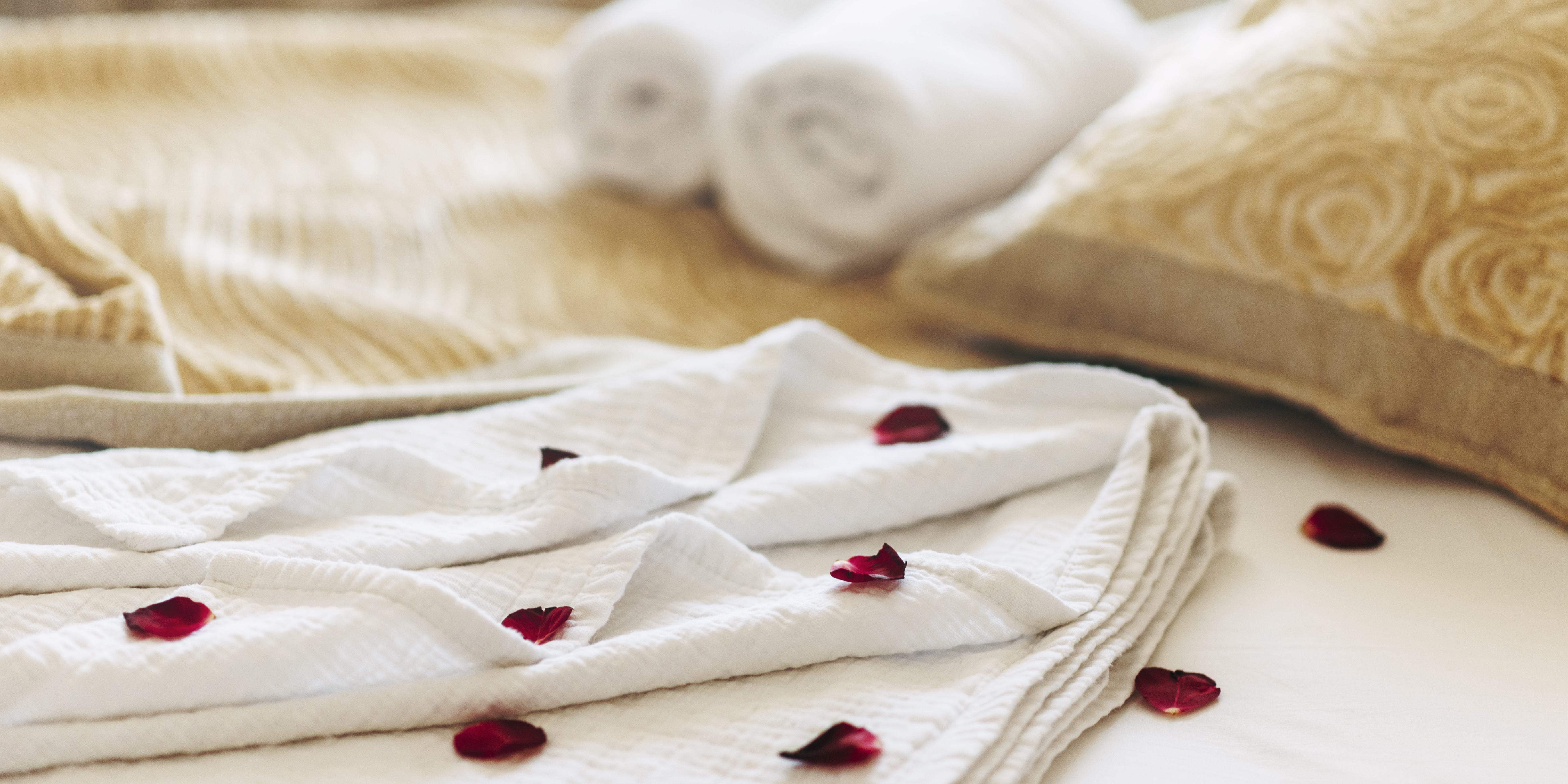 Towel with red rose petals sprinkled on it