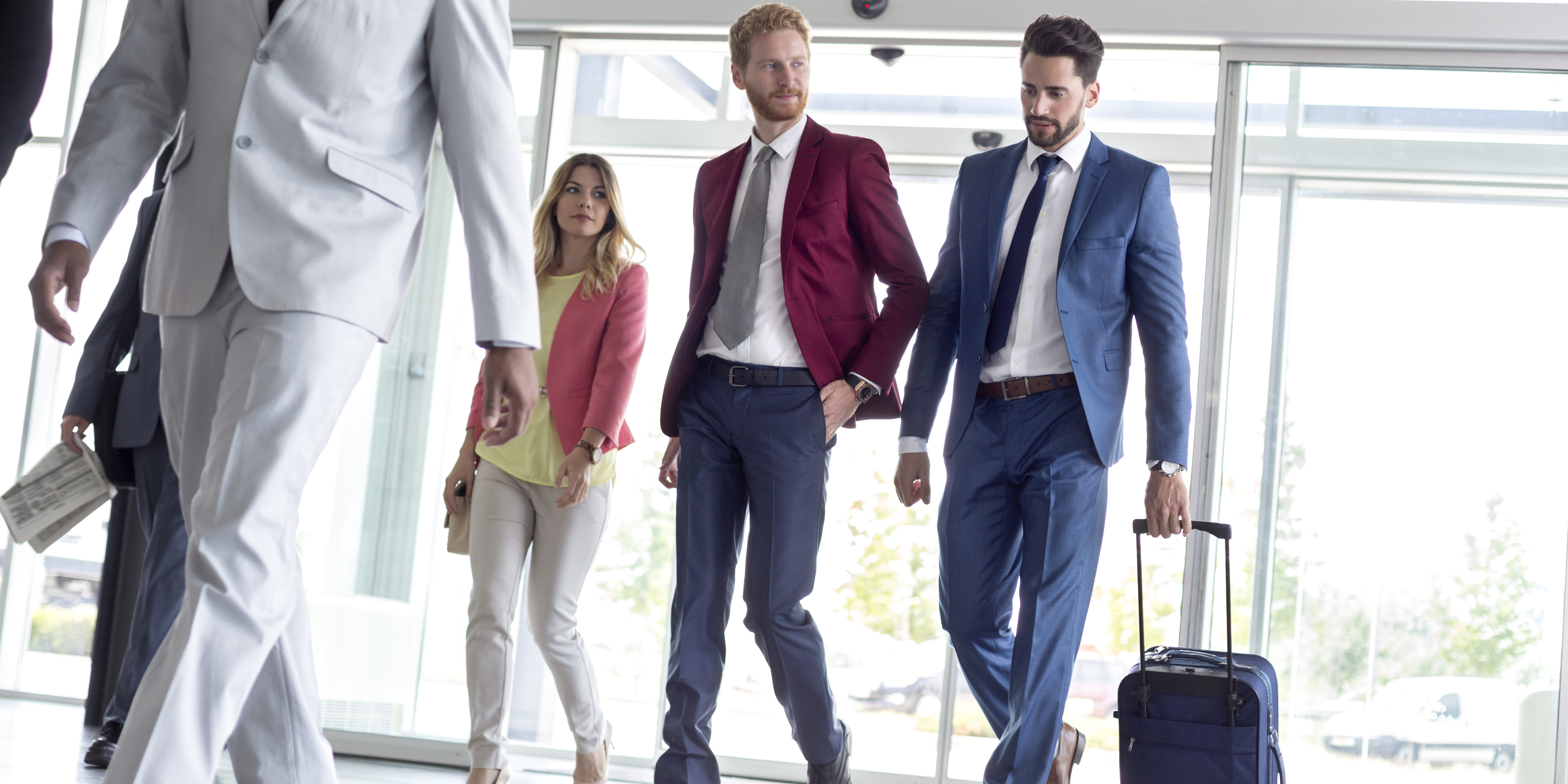 two businessmen arriving at airport with luggage