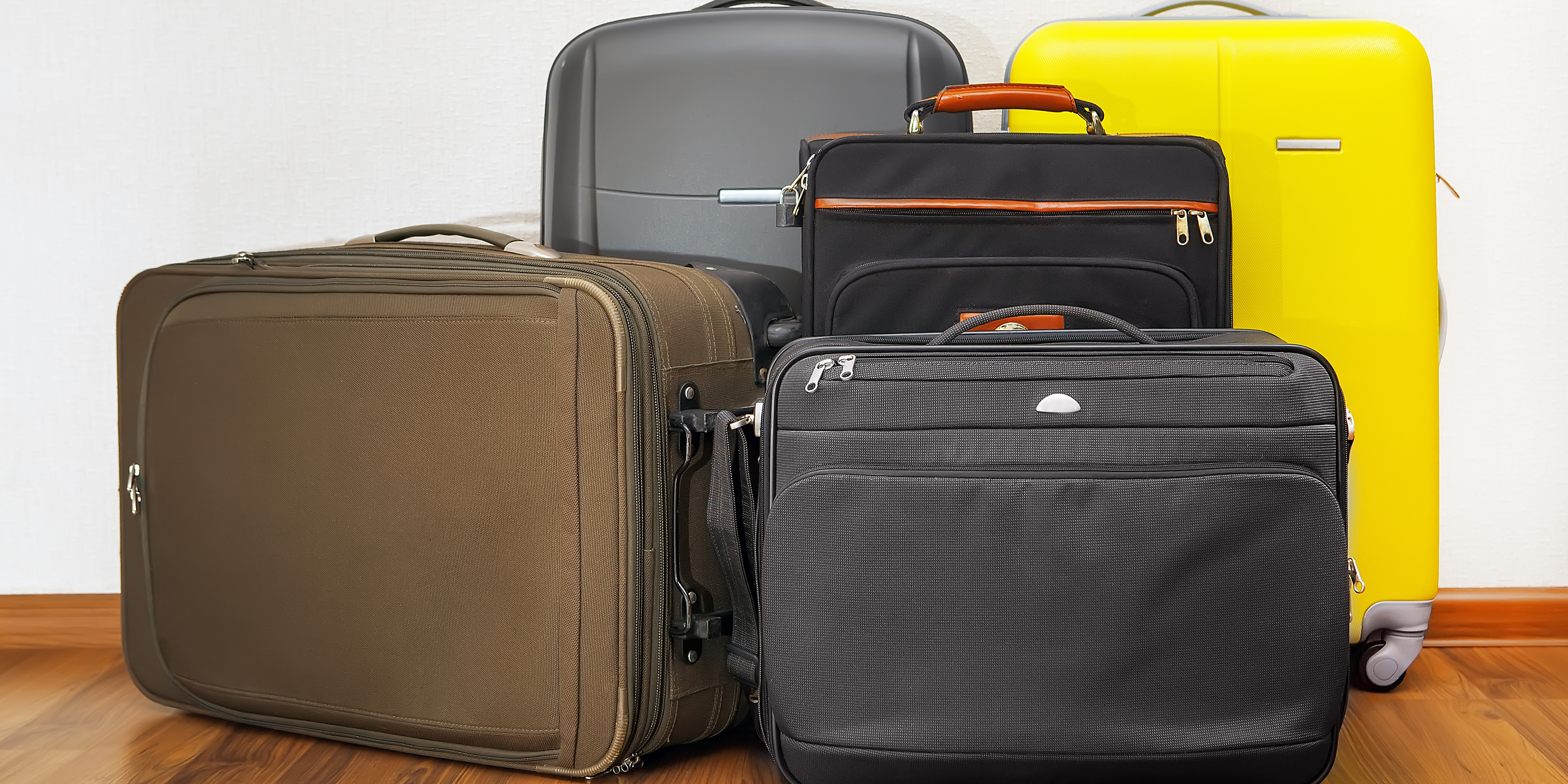 group of luggage bags in front of wall